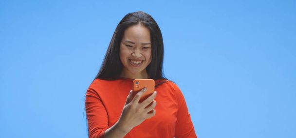 Jonge vrouw video chatten met smartphone - Foto, afbeelding