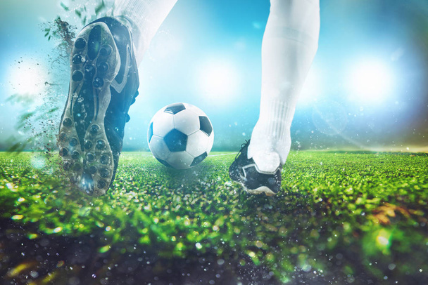 Футбольная сцена в ночном матче с крупным планом футбольной обуви, ударяющей по мячу
 - Фото, изображение