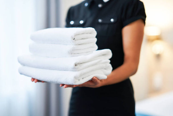 Maid with fresh towels in hotel room - 写真・画像