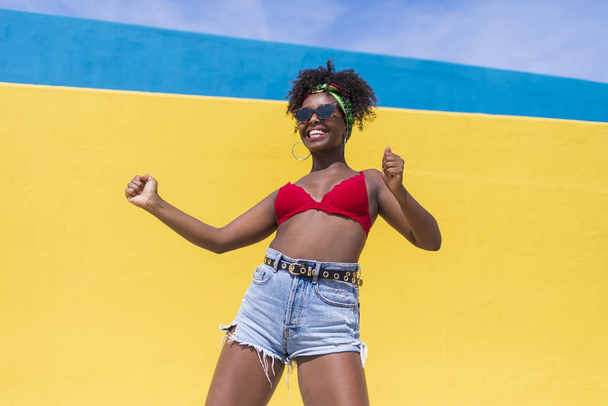 fun young afro american woman laughing with arms raised - Фото, изображение