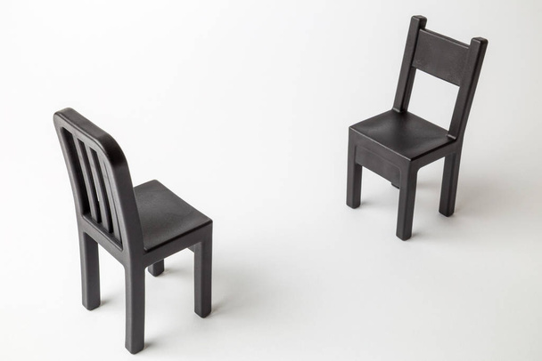Black retro chairs against white background minimal creative concept. - Zdjęcie, obraz