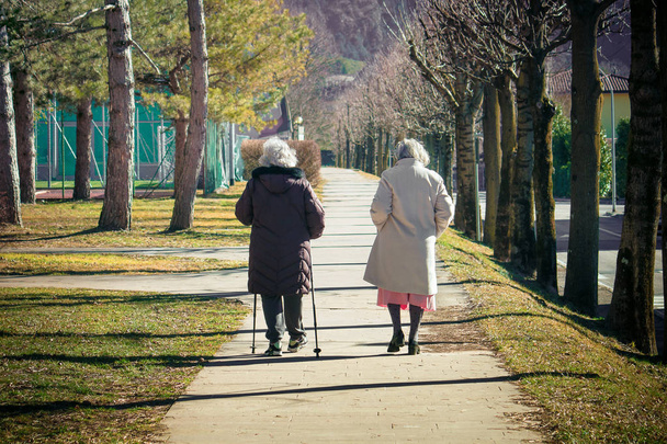 Dos mujeres mayores dando un paseo saludable. Viejas amigas caminando en un parque
 - Foto, imagen