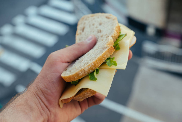 White bread Sandwich with Hum and Salad in mans hand in Monaco - 写真・画像