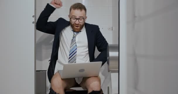 Businessman with notebook sitting in toilet. - Felvétel, videó