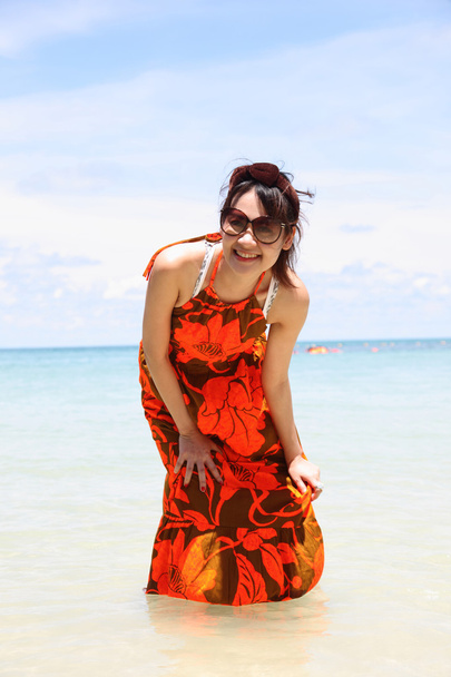 Giovane bella donna in abito estivo e occhiali da sole sulla spiaggia
 - Foto, immagini