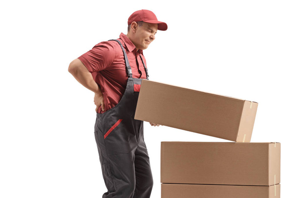 Male worker lifting a package and holding his painful back - Φωτογραφία, εικόνα