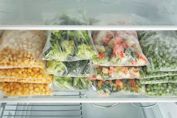 Plastic bags with different frozen vegetables in refrigerator - Zdjęcie, obraz