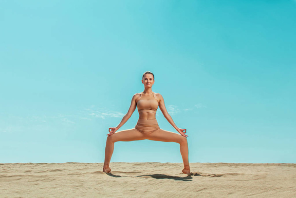 Yoga fitness workout. Individual sports recreation. Sporty and fit young woman athlete doing training on the sky background. The concept of a healthy lifestyle and sport. - Zdjęcie, obraz
