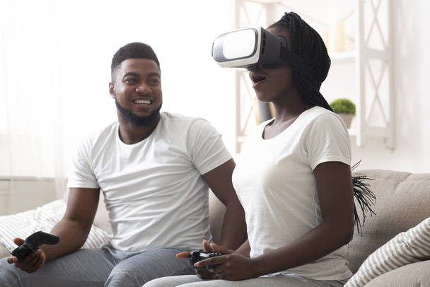 Casal negro tentando óculos VR em casa, jogando Videogame juntos
 - Foto, Imagem