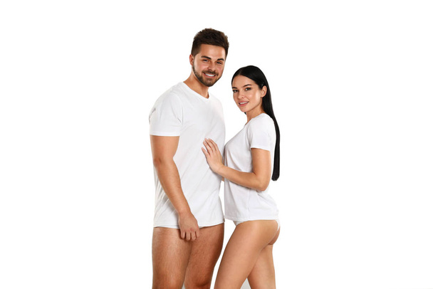 Young couple in white t-shirts and underwear on light background - Valokuva, kuva