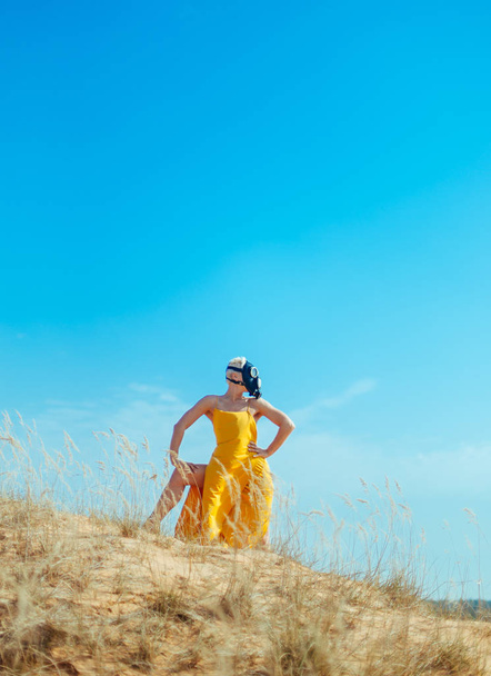Girls in yellow dress and Gasmask dancing on the sand dunes - Foto, Bild