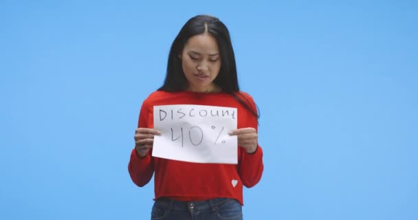 Young woman holding discount sign - Filmati, video