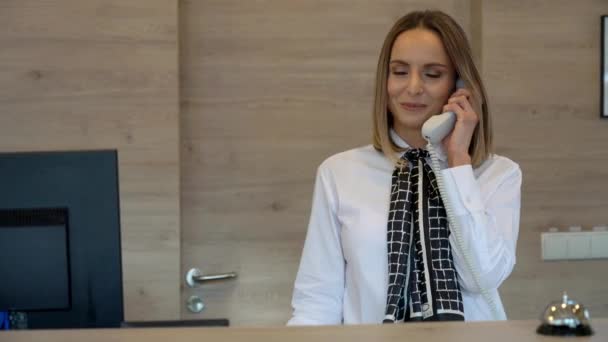 Dospělá žena pracující na recepci nebo v hotelové společnosti - Záběry, video
