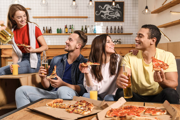 Group of friends having fun party with delicious pizza in cafe - Foto, Bild
