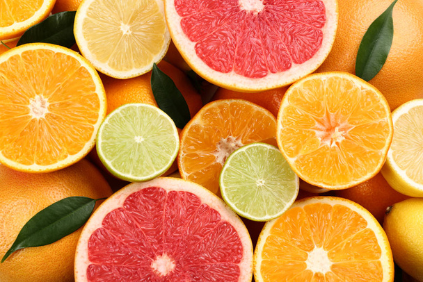 Tangerines and different citrus fruits as background, top view - Valokuva, kuva