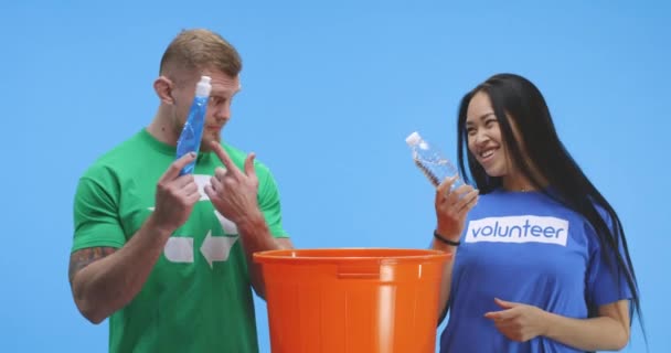Eco-consciente homem e mulher colocando garrafa em balde
 - Filmagem, Vídeo