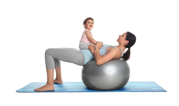 Young woman doing exercise with her son isolated on white. Time for fitness - Photo, Image