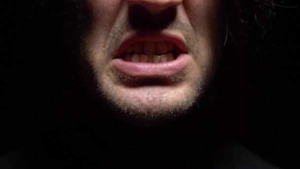 closeup. male mouth with crooked teeth screaming. Black background. - Foto, Imagen