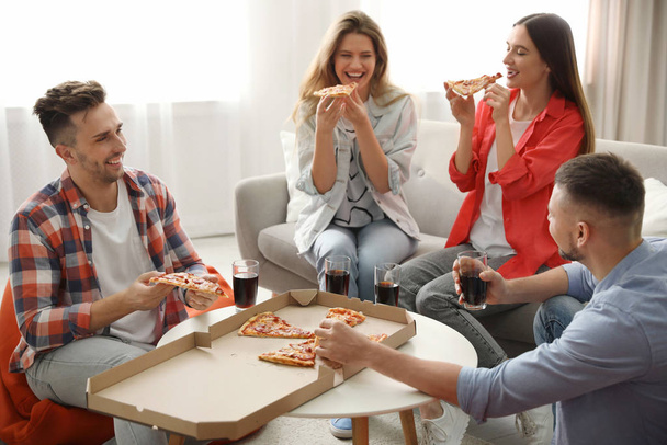 Group of friends eating tasty pizza at home - Fotoğraf, Görsel