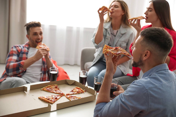 Group of friends eating tasty pizza at home - Фото, изображение