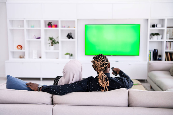 African Couple Sitting On Sofa Watching TV Together - Valokuva, kuva