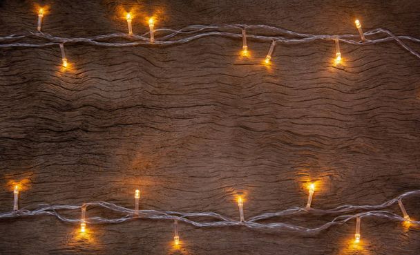 Christmas lights on wooden plank background. Merry Christmas and - Foto, Imagen