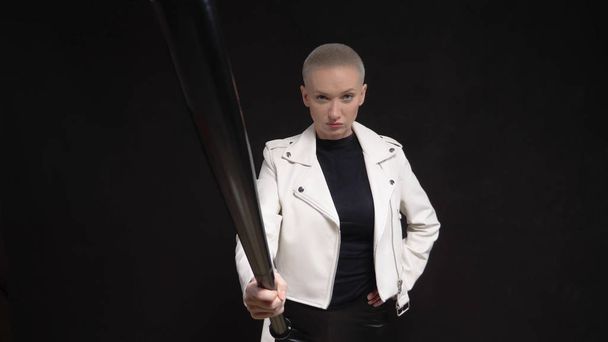 beautiful  short haired woman in a white leather jacket with a baseball bat  - Fotó, kép