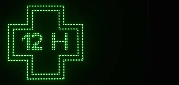 croix verte de produits pharmaceutiques électroniques avec fond noir - Photo, image