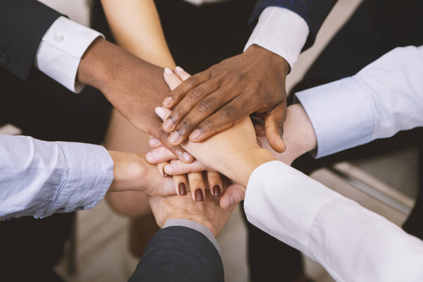 Multiethnic corporate teame stacking hands together in office - Photo, Image