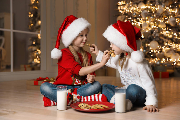 Petits enfants mignons mangeant des biscuits dans le salon. Noël ti
 - Photo, image