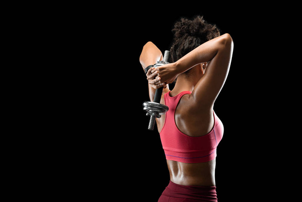 Black athletic girl working on her back muscles, using barbell - Fotó, kép