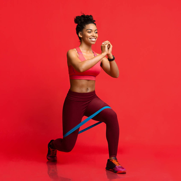 fröhliches Afro-Fitness-Girl macht Workout mit Widerstandsband - Foto, Bild