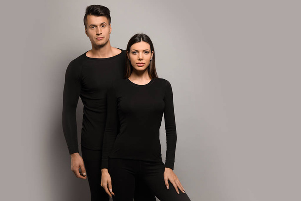 Couple wearing thermal underwear on grey background. Space for text - Photo, image