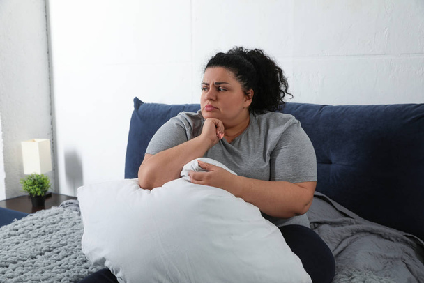 Depressed overweight woman with pillow on bed - Zdjęcie, obraz