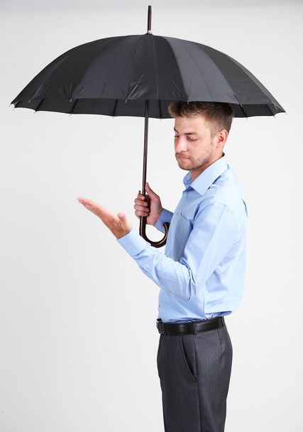 Businessman with umbrella. on gray background - Foto, afbeelding