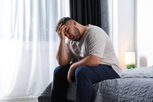 Depressed overweight man on bed at home - Foto, immagini