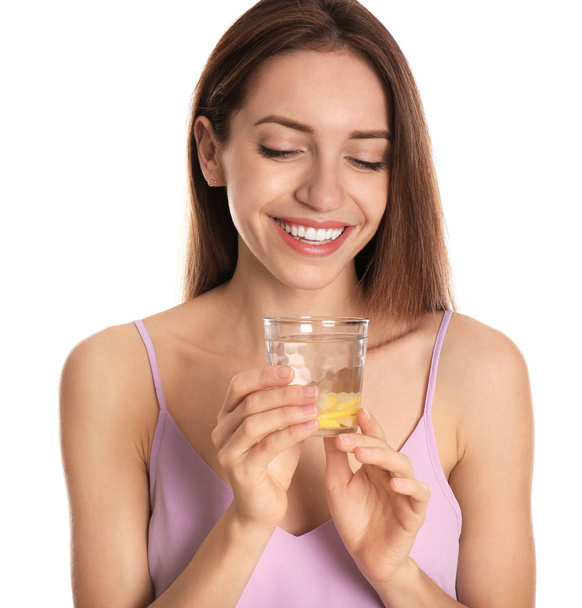 Young woman with glass of lemon water on white background - Foto, Imagen