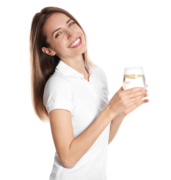 Young woman with glass of lemon water on white background - Valokuva, kuva