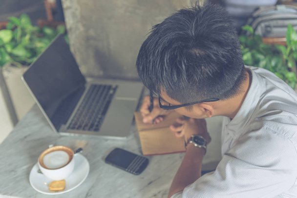 asiatischer Mann schreibt Notizen im Café - Foto, Bild