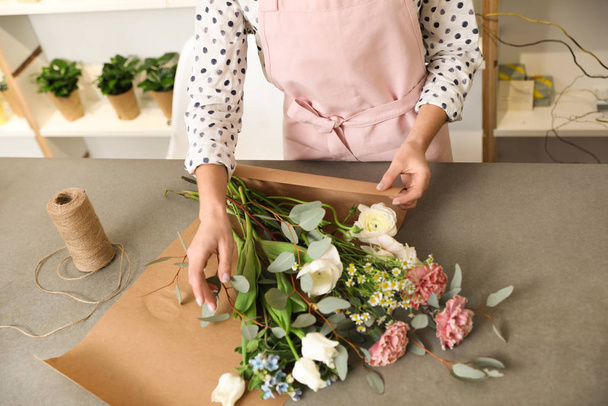 Florist making bouquet with fresh flowers at table, closeup - Photo, Image