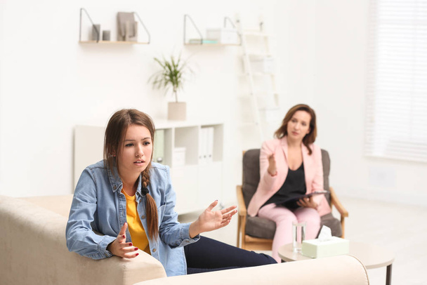 Psychotherapist working with teenage girl in office - Foto, imagen