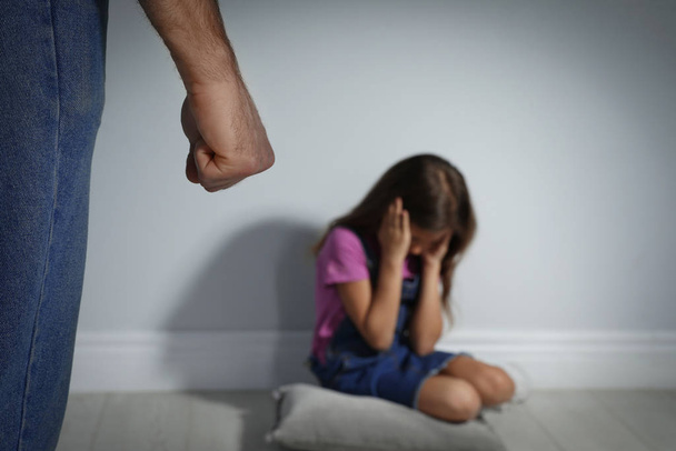 Man threatening his daughter indoors, closeup. Domestic violence - Foto, imagen