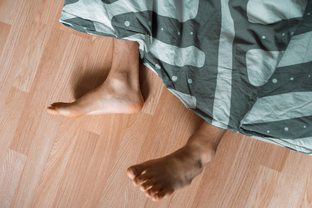 vista superior de jovem do sexo masculino dormindo no chão, conceito saudável, posição reta no chão de madeira
 - Foto, Imagem