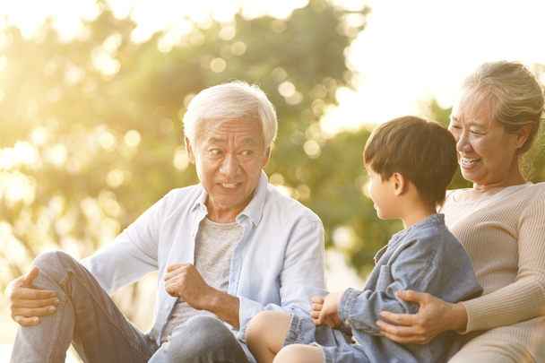 бабушки и дедушки из Азии хорошо проводят время с внуком
 - Фото, изображение