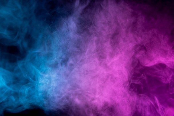 Zamrożony abstrakcyjny ruch dymu eksplozji wielu różowych i niebieskich kolorów na czarnym tle. Tło od dymu vap - Zdjęcie, obraz
