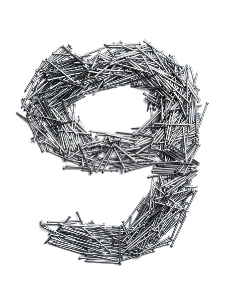 Арабская цифра "9" от мелких железных гвоздей на белом изолированном фоне. Промышленный образец тонких ногтей для крепежа. яркие цифры для дизайна
.  - Фото, изображение