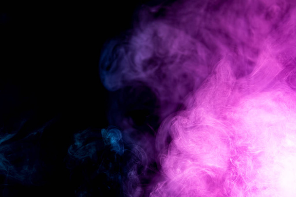 Abstraktní umění zbarvený fialový kouř na černém izolovaném pozadí. Zastavit pohyb pestrobarevného kouře na tmavém pozadí - Fotografie, Obrázek