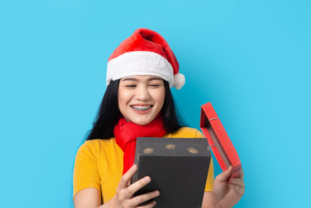 Asian woman in yellow dress wearing red scarf and Santa hat, hol - Foto, imagen