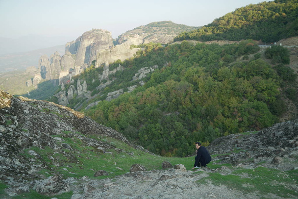 Azjatycki podróżnik cieszący się widokiem, pozować w Kalampaka Hills, Varlaam, Grecja - Zdjęcie, obraz