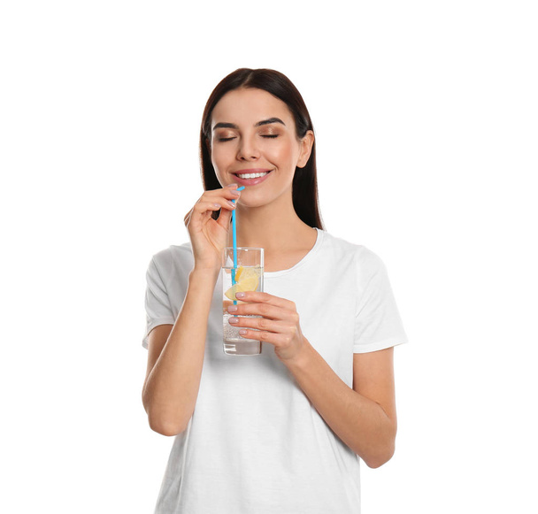 Beautiful young woman drinking tasty lemon water on white backgr - Foto, immagini
